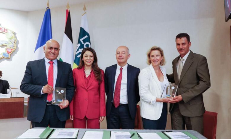 Cinq personnes, trois hommes et deux femmes, se tiennent côte à côte, souriantes, dans une salle de conférence à Nantes. Chacun tient une plaque ou un certificat. Des drapeaux et des documents de la conférence sont exposés sur la table devant eux, reflétant l'esprit des initiatives de la Loire-Atlantique.