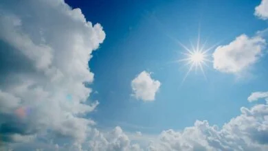 Ciel bleu clair au-dessus de Nantes, parsemé de nuages blancs et duveteux, et soleil qui brille. Les rayons du soleil créent un effet radieux, projetant de la lumière sur la Loire-Atlantique. La scène évoque une sensation de tranquillité et de temps clair.